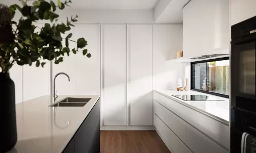 Modern kitchen with white cabinets, a sleek island with sink, and a window above the counter