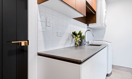 laundry area with white table cabinets