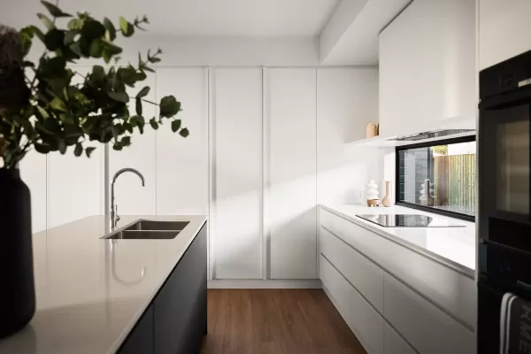 Modern kitchen with white cabinets, black island, stainless steel sink, and large window