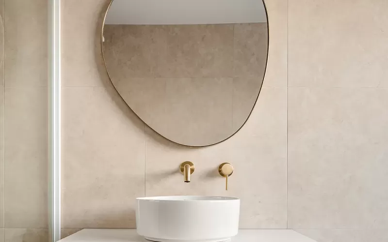 A bathroom with a sink and mirror above a counter