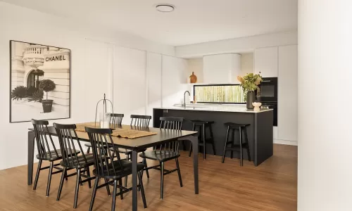 Modern kitchen and dining area with black chairs, a Chanel print, and a white island with black stools